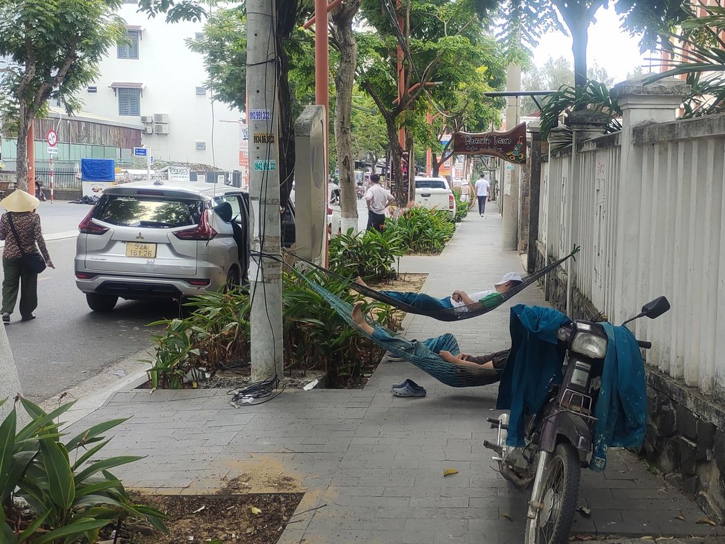 Спят в гамаке через тротуар